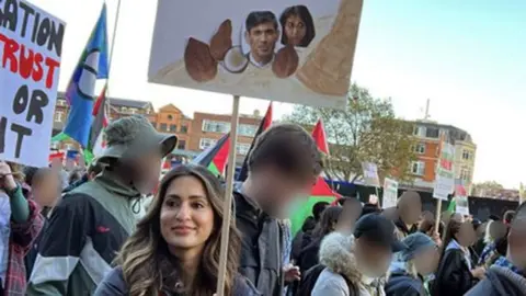 Marieha Hussain carrying a placard