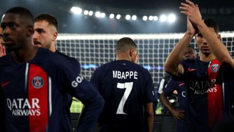 Kylian Mbappe has his back to the camera as his team-mates applaud the Paris St-Germain fans following their Champions League exit