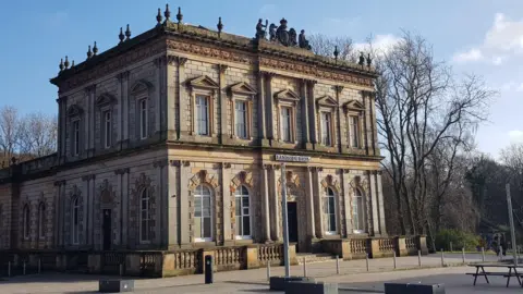 The Langside Halls building in Glasgow, a historic sandstone building, pictured on a sunny day.