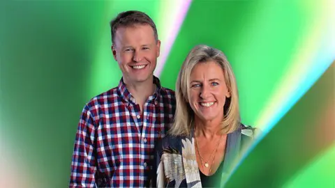 Chris Buckler and Sarah Brett smiling at the camera against a computer generated green and white background