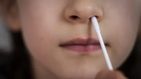 PA Media A person taking a Covid-19 lateral flow test