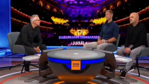 Gary Lineker, Joe Hart and Danny Murphy sit in the Match of the Day studio, with a backdrop of the Royal Albert Hall