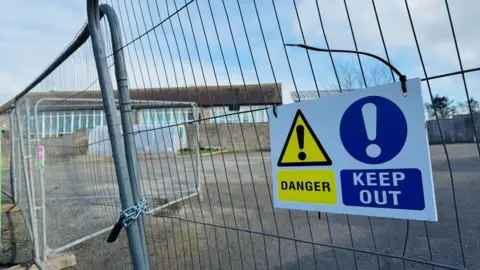 A 'danger - keep out' sign on a fence outside Slains School. 