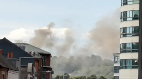 Smoke in the skies viewed from down a city centre street