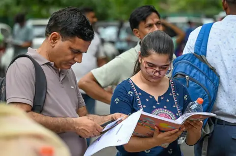 Hindustan Times via Getty Images A student arrives at a NEET centre in Delhi with her parent.