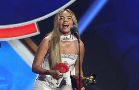 Getty Images Karol G smiles as she accepts her Latin Grammy award