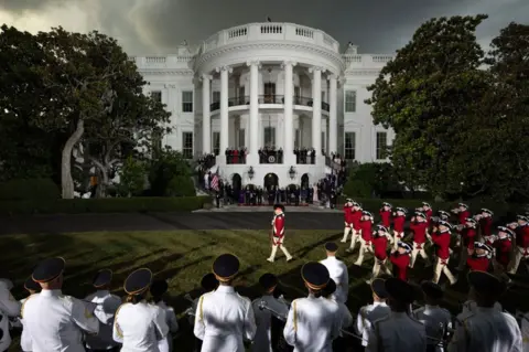 Tom Brenner/Getty Images US President Joe Biden and First Lady Jill Biden watch the Old Guard Fife and Drum Corps march on the South Lawn of the White House