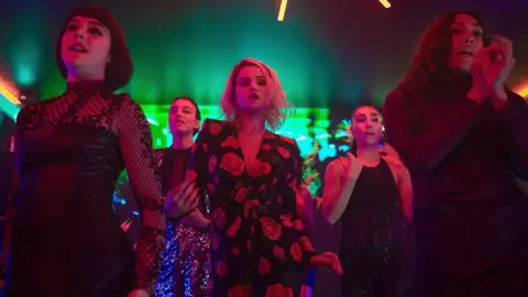 Netflix Selena Gomez successful  the centre of a radical  of women dancing with nightclub-style greenish  and reddish  lights