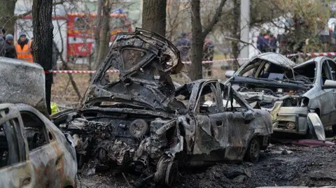 Getty Burnt cars lie in the yard of damaged residential buildings after a Russian missile attack on November 18, 2024 in Sumy, Ukraine