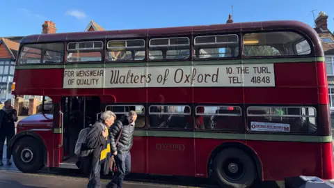 A large vintage red bus stopped.