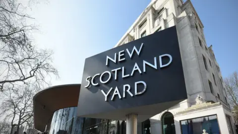 New Scotland Yard sign as Met Police confirm officers are investigating reports of clashes in north-west London