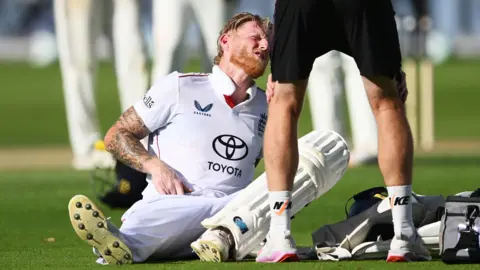 Ben Stokes grabs his groin as he receives treatment