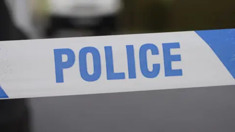 A stock image of blue and white police tape.