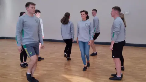 Scór dancers. They're dancing together and wearing their grey uniform tops