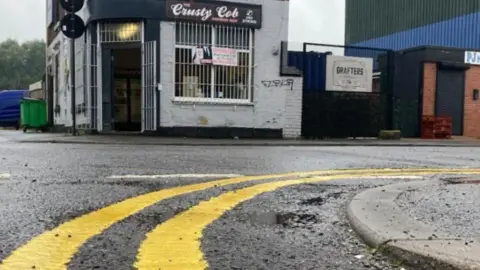 Double yellow lines on a road in front of a cafe