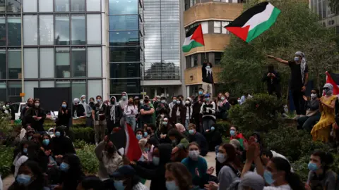 Reuters Protesters stand in front of a university building during a demonstration in support of Palestinians, at Oxford University, amidst the ongoing conflict.