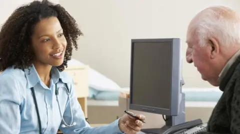 Getty Images A doctor talks to a patient