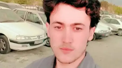 Abdul Wali, 18, in a selfie picture with cars behind him