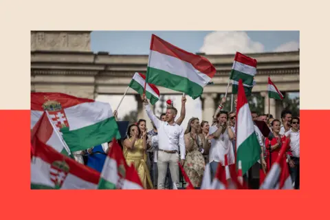 Janos Kummer/Getty Images Peter Magyar holds the Hungarian flag at a campaign rally