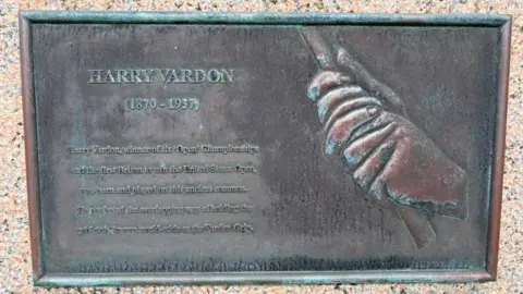 A plaque showing a pair of hands doing the Vardon grip. There is a written description of the technique alongside it. 