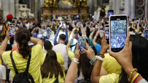 EPA is a crowd of young people with smartphones in Bashilica Saint Peter, Vatican.