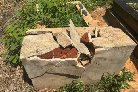 A tomb in the municipal Cola Cemetery with a broken concrete head where the cross was placed once. 