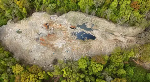 An aerial shot of Hoads Wood which shows the extend of fly tipping amid a green woodland.