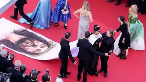 Getty Images Massiel Taveras being spoken to by security guards on the red carpet