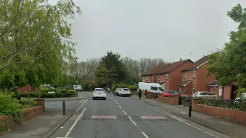 A residential street in Redcar, with two red-coloured speed bumps on the road.