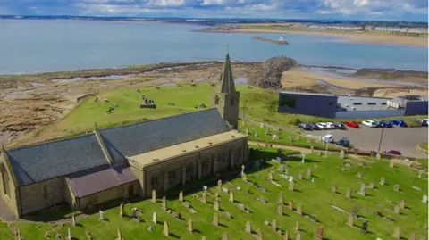 St Bartholomews, Newbiggin-by-the-Sea  An aerial view of St Bartholomew Church in Newbiggin with the Maritime Centre behind and the sea in the background.