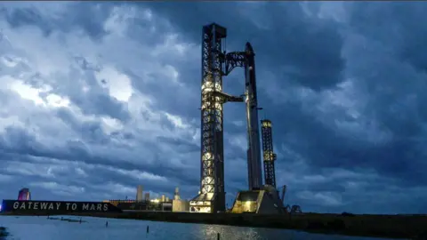 Stormy weather, rolling in from the Gulf at sunrise, surrounds the SpaceX Starship spacecraft and the Super Heavy Booster as preparations continue for the 12th test flight of the Starship spacecraft in Starbase, Texas, U.S., May 21, 2026.
