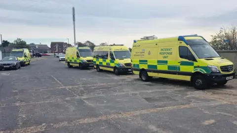 Ash Chapman Four ambulances parked either side of a road