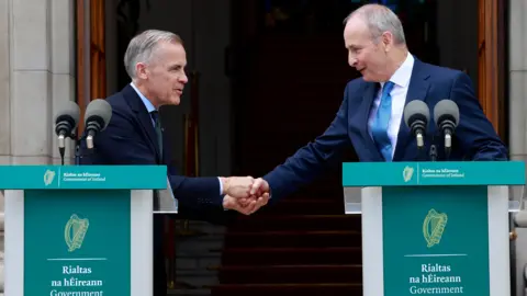 Taoiseach Micheal Martin TD (right) and Canadian Prime Minister Mark Carney shake hands during a press conference, following a a visit to Government Buildings in Dublin