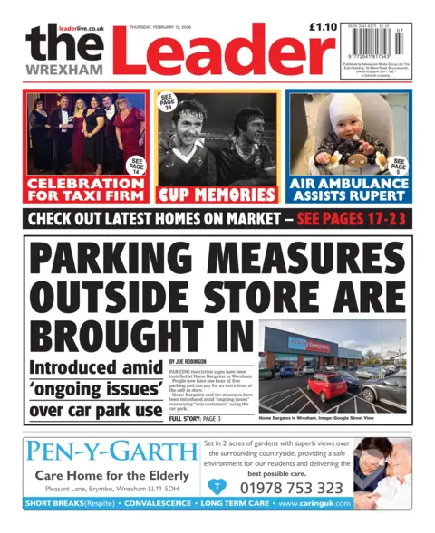 Wrexham Leader Front page of the Wrexham Leader. The headline reads 'parking measures outside store are brought in', with an inset photo of said car park. Above are three boxes with headlines, the first reads "Celebration for taxi firm", with a photo of men and women dressed up, the second is a black and white image of two men with the headline "Cup memories" and the third is of a boy with a bandage on his head and the headline "Air ambulance assists Rupert"