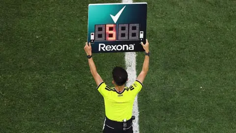 The fourth official holds up the substitution board during the Fifa World Cup match between Iran and New Zealand