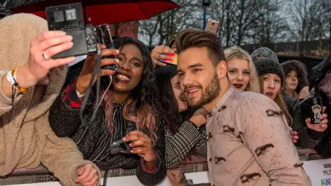 BBC A man is taking pictures with fans at an awards show