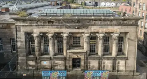 Temple Works mill in Leeds. A stone building with six pillars and glass roof.