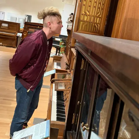 Sam Battle stares at a mechanical piano inside Vienna's Museum of Science and Technology