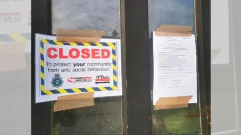 A sign on the front of a door reads closed in red capital letters next to an eviction notice.