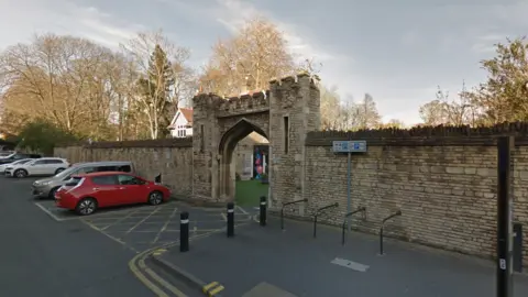 Google Chauffeurs Cottage visible through the a cathedral gateway on St Peter's Road in Peterborough