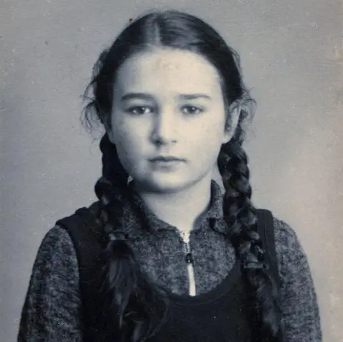 Hedi Argent A black-and-white portrait of a 10-year-old girl Hedi Argent, with braided hair, looking at the camera.