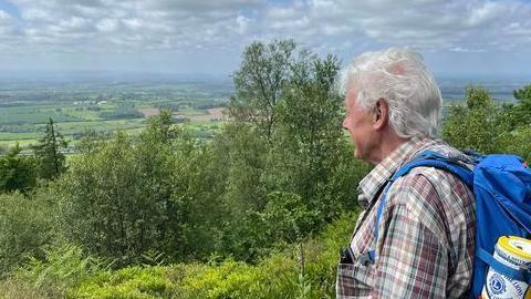 Mr Ogley looks at the view from the top of a hill