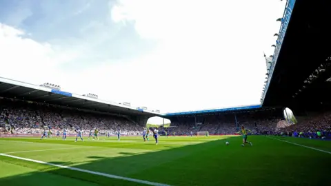 Getty Images Hillsborough football stadium. Players can be seen on the pitch and the stands are full of people.