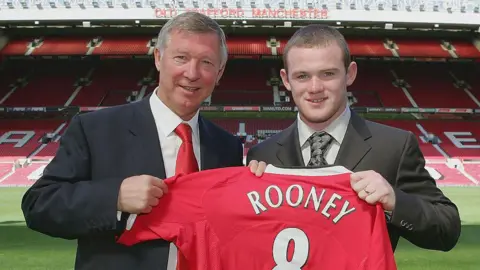 Sir Alex Ferguson stands with Wayne Rooney after signing him from Everton