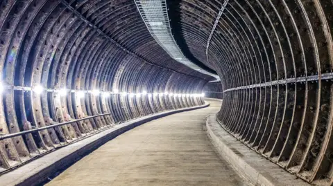 Birmingham Heritage Week The inside of a mail delivery tunnel. The tunnel snakes around with a lights on the left hand side