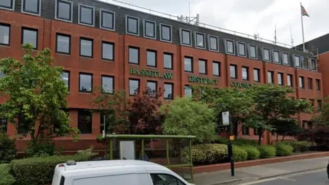 Google Red brick council building for Bassetlaw District Council on a main road opposite a bus stop with several windows and trees