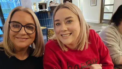 Sharon Donaghy Mary and Sharon Donaghy taking a selfie as they sit down at a restaurant.