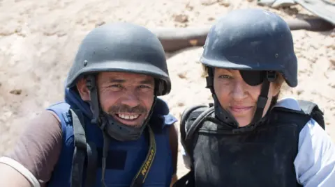 BBC/Arrow International Media/Paul Conroy Image of Paul Conroy and Maire Colvin in protective helmets and bulletproof vest in Libya