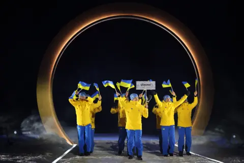 Athletes of Team Ukraine enter during the opening ceremony of the 2026 Winter Olympics