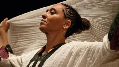 Mario Di Bari Gabriella Ghermandi on stage in Ethiopian dress.